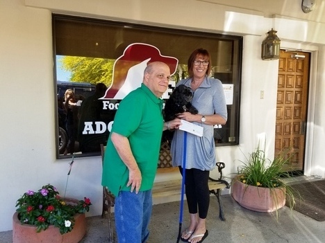 Industry Relations and Communications Chair Mark Torpey presents a donation check to Victoria Cowper of Foothills Animal Rescue